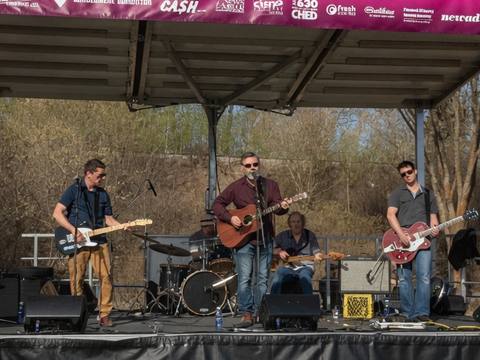 The Threads performing on stage at Run Wild Edmonton event with sponsor banners